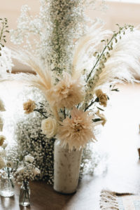 Witte vaas met bloemen tijdens ceremonie bruiloft