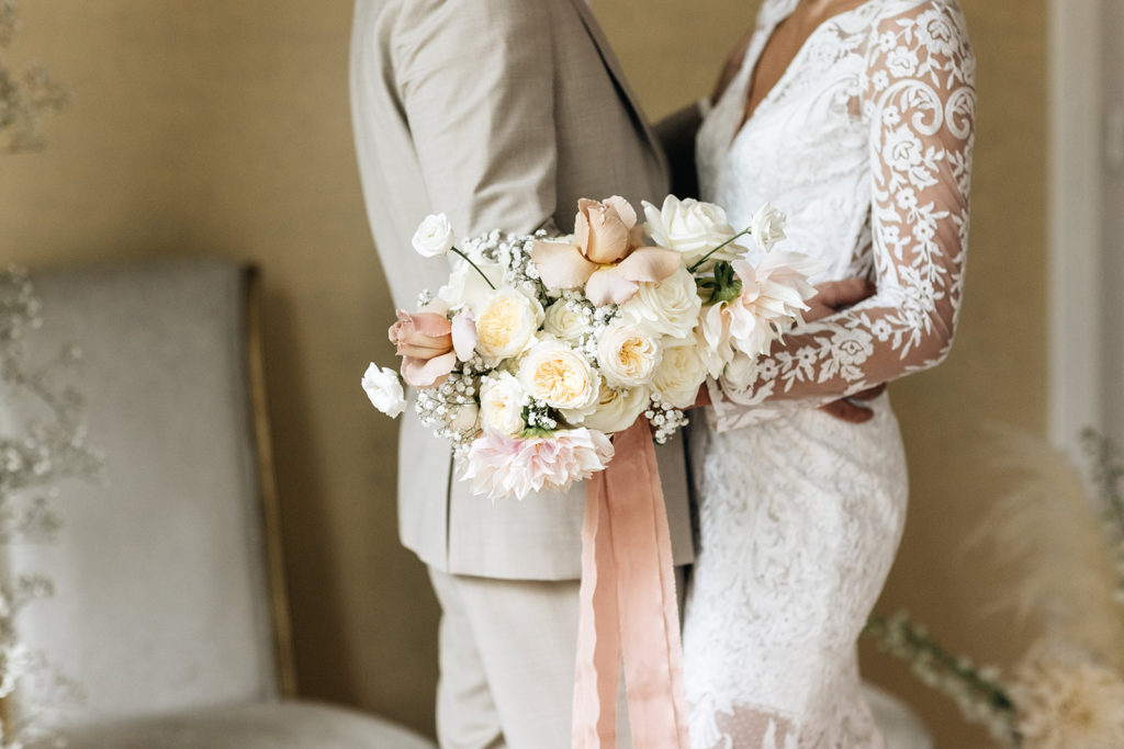 Bruid en bruidegom met bruidsboeket in neutrale kleur op bruiloft