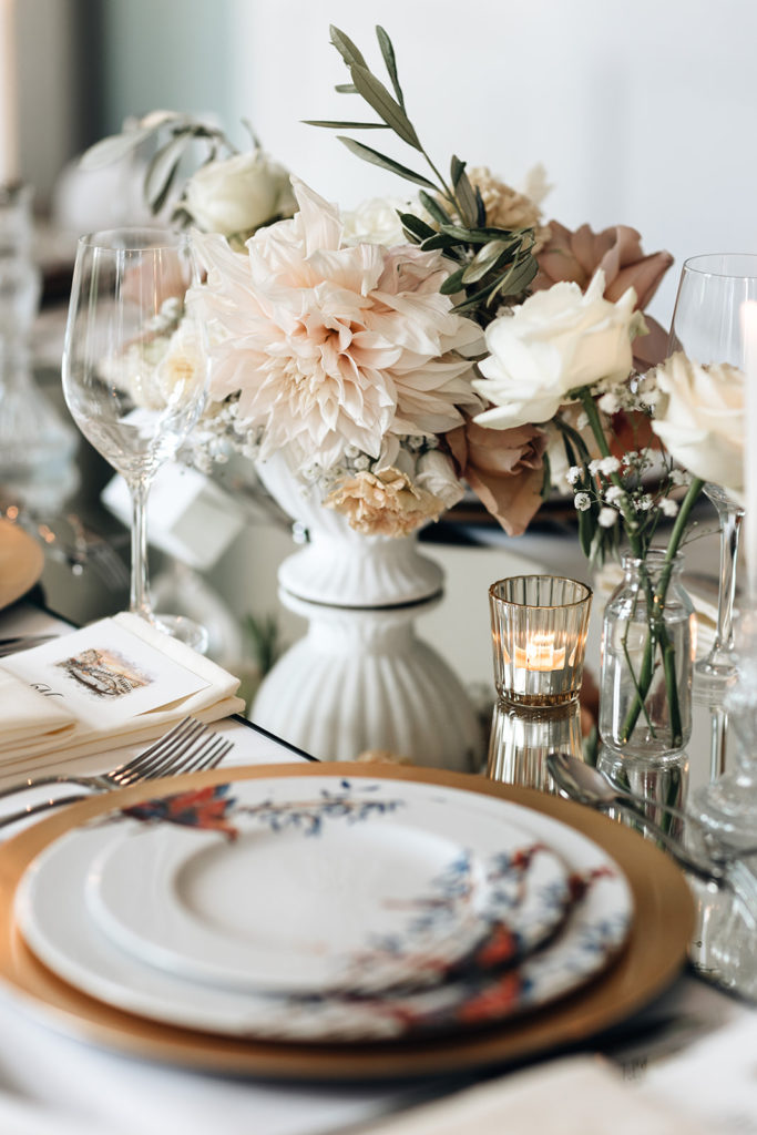 Dinertafel bruiloft met bloemen in vaas met olijftak